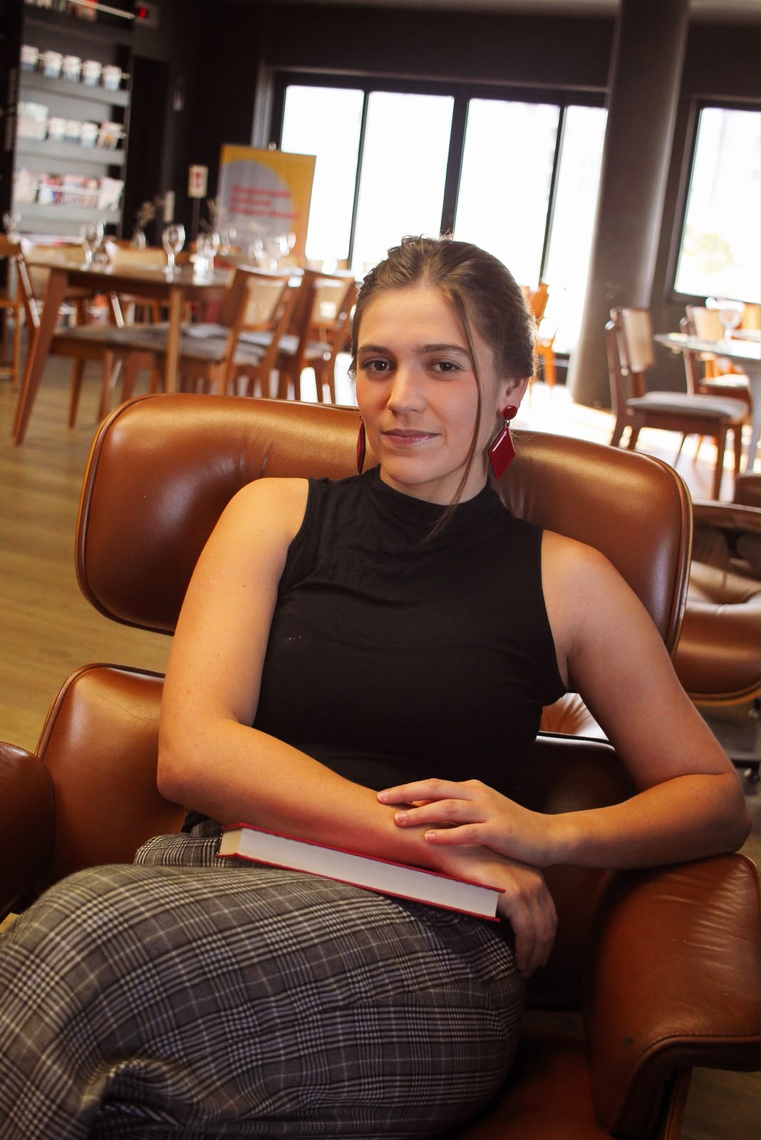 Lais Morandin em uma biblioteca, segurando um livro